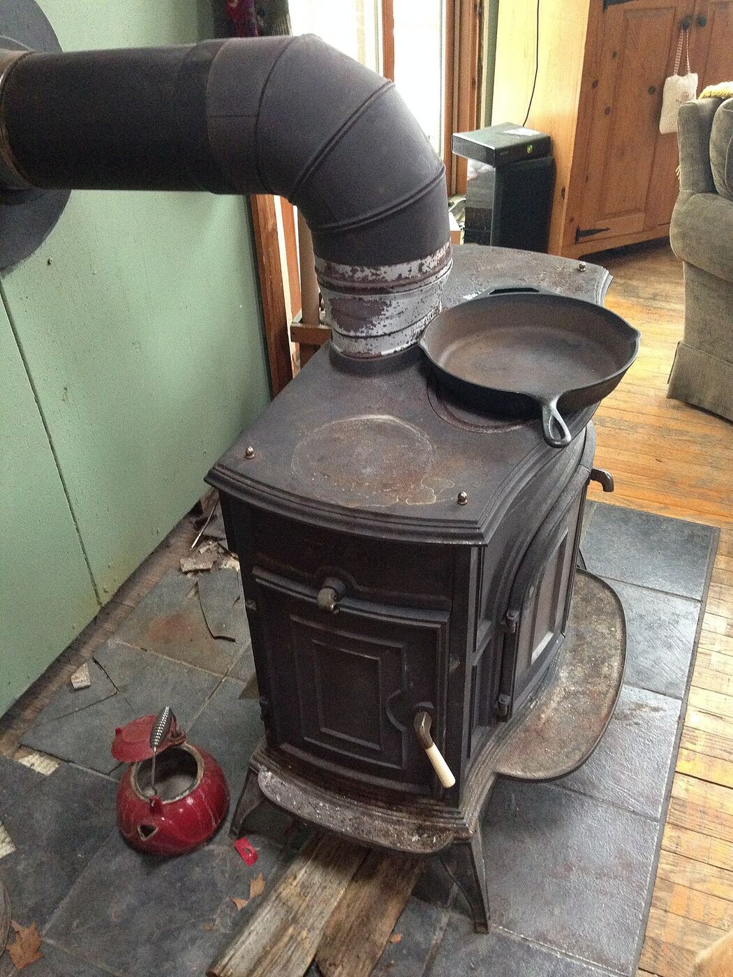 Cast-iron wood stove with stovepipe and a kettle